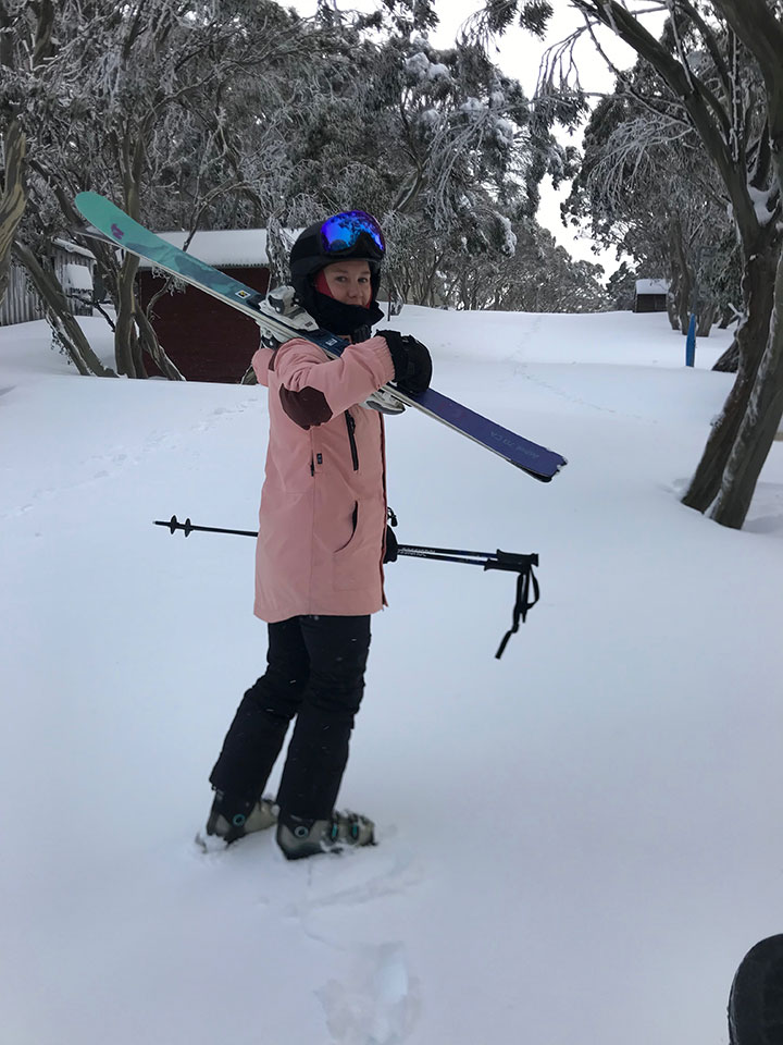 Child in snow holding skis at Gallows Court, Mt Hotham
